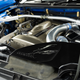 a close-up shot of the engine of an R34 nissan gt-r, with engineer hiroshi tamura's signature on the air intake